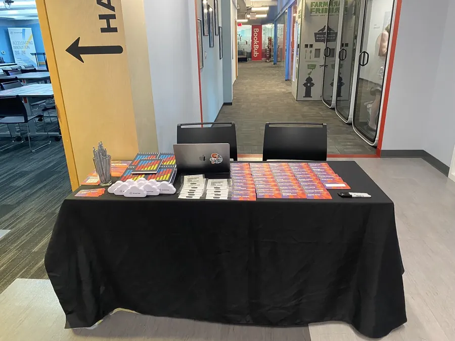 A branded event table set with printed materials before guests arrive